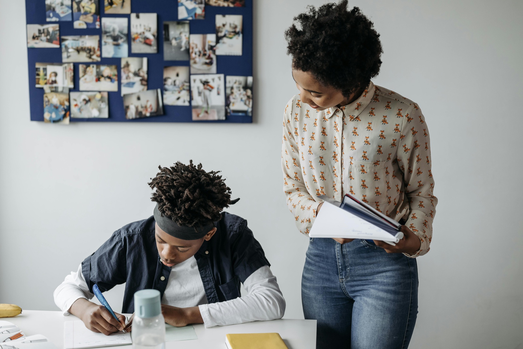 A mentor supporting a young person at a study table