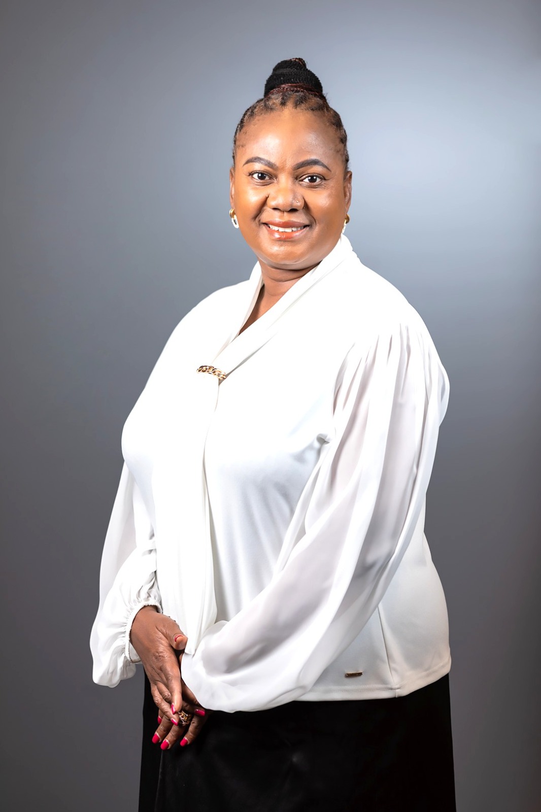 Faith Mabu Nteta in a white blouse against a studio backdrop