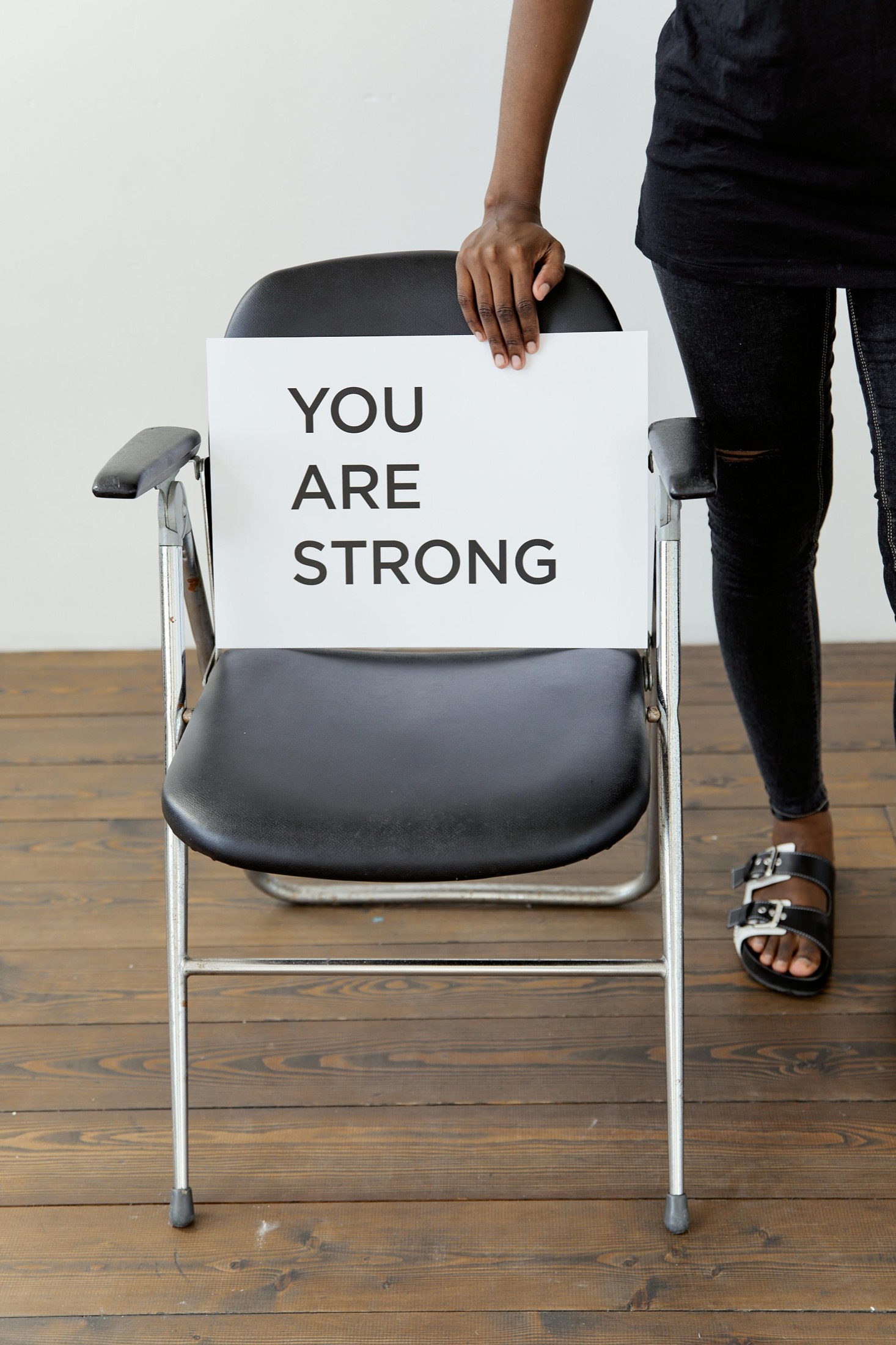 A person holding a sign that reads you are strong