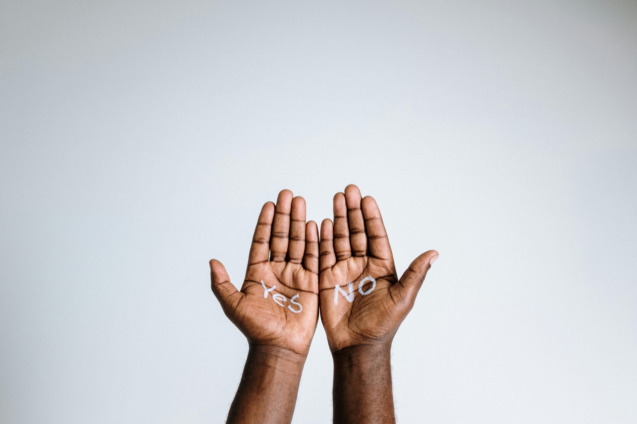 Hands raised with the words yes and no written on the palms