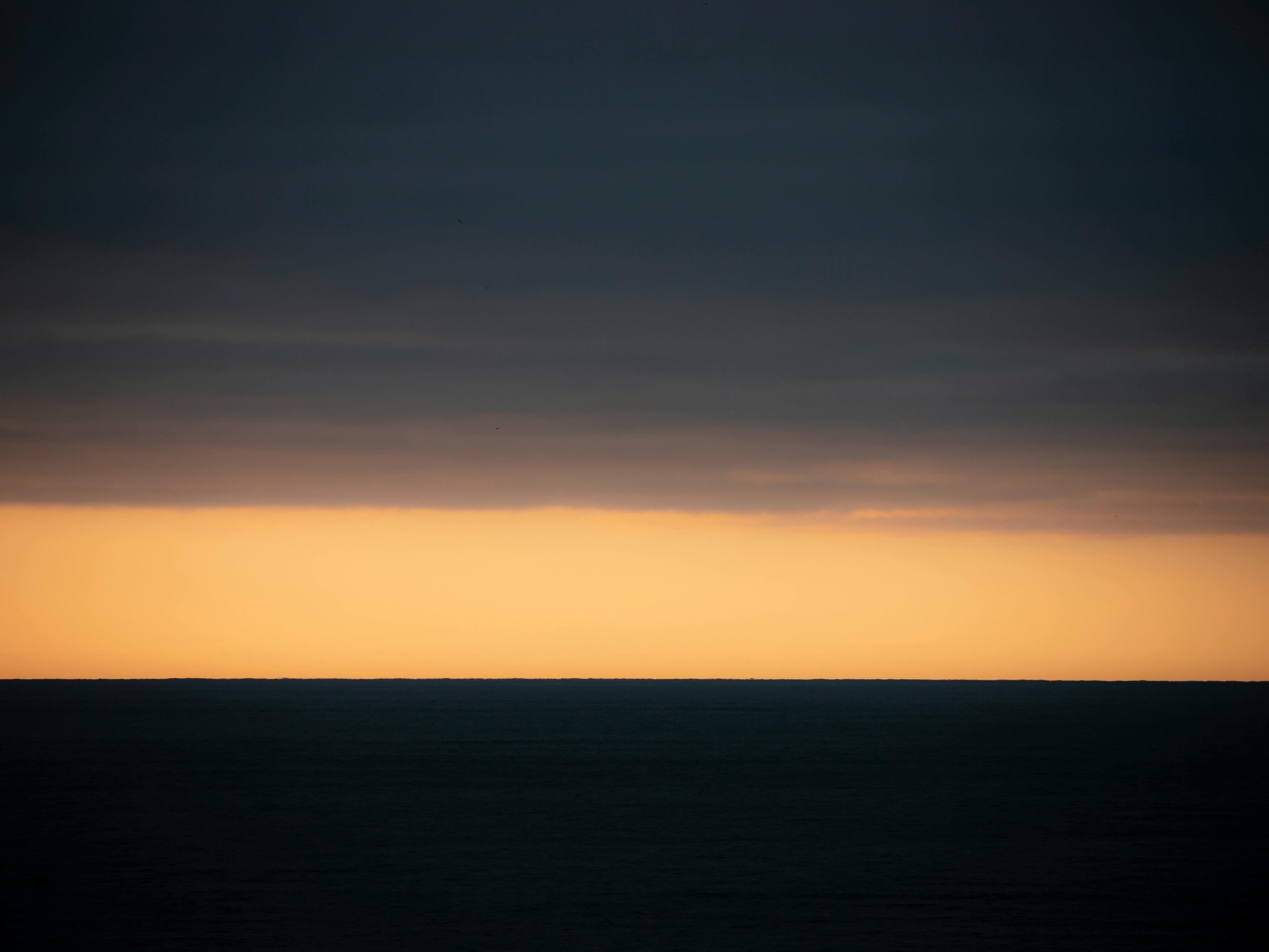 A distant horizon under a dark sky at sunset